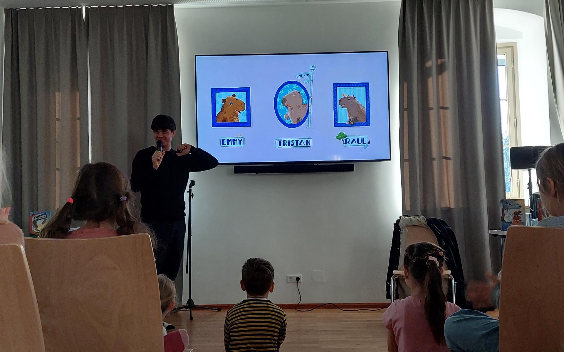 Der Autor steht vor einem Bildschirm und stellt die Wasserschweine vor